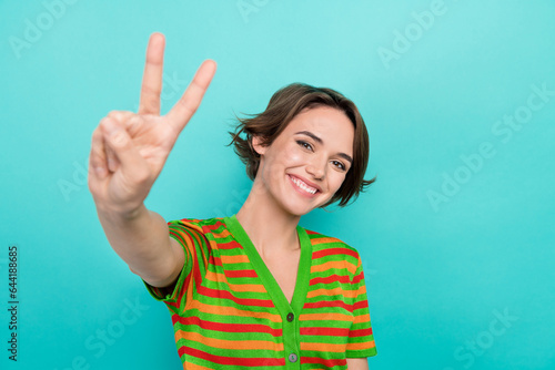 Photo of funny sweet lady wear striped cardigan showing you v-sign smiling isolated teal color background