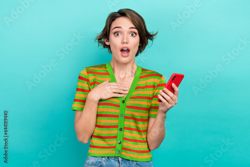 Photo of impressed funny lady wear striped cardigan texting modern gadget isolated teal color background