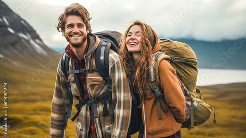 Happy couple of tourists with backpacks hiking in countryside.