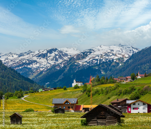 Summer Alpine mountain country view with grassy meadow and road to village (Austria) © wildman