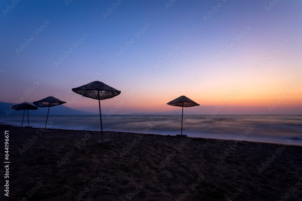 An empty beach landscape photographed with a long exposure technique at sunset. An empty beach landscape photographed with a long exposure technique at sunset.