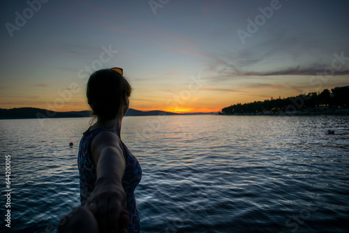 woman looking at the lake at sunset
