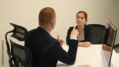 Business partners communicate in sign language. A deaf boss gives a task to a subordinate woman.