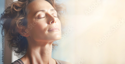 Close-up face of focused middle-aged woman doing breathing yogic practices at home. Woman with closed eyes meditating. Close-up. Banner. photo