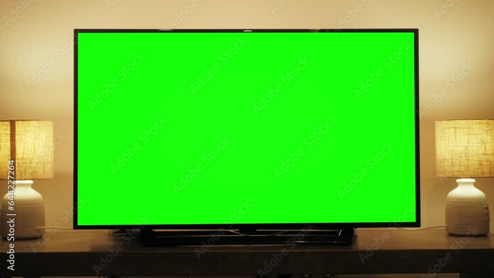 LcD smart TV screen with a blank green background in the living room. Chroma key screen for advertising. LcD smart TV screen with a blank green background in the living room. Chroma key screen for advertising.