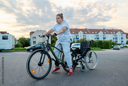 Boy transfers from wheelchair to bike, activity rehabilitation health concept