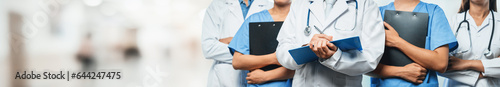 Confident medical staff team with doctor nurse and healthcare specialist professions people in blurry hospital corridor background. Medical and healthcare community in panoramic banner. Neoteric