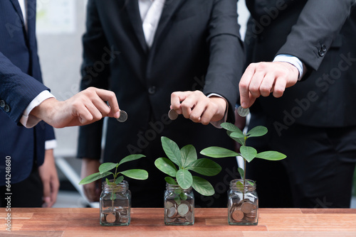 Fotografi Business people put money saving into jar filled with coins and growing plant for sustainable financial planning for retirement or eco subsidy investment for environment protection