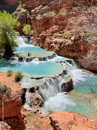 Turquoise tiered waterfall at Beaver Falls found within Havasupai Reservation, Grand Canyon surrounded by red rock.  © Enrique