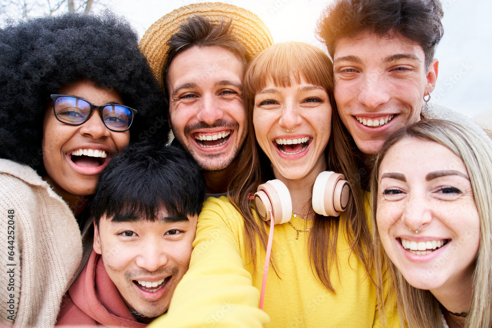 Obraz premium Selfie of a group of multiracial students and laughing a lot while they they look at camera. They look happy and friendly faces. Portrait of a community of millennial generation people