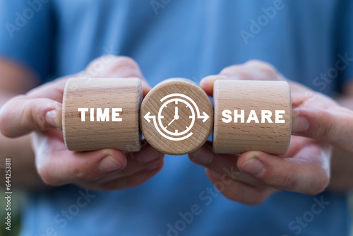 Hands holding wooden blocks with clock icon and sees inscription: TIME SHARE. Concept of business share time. Timeshare. Time to share.