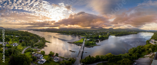 Aerial panorama view of Kenmare Bay at the entrance of the Ring of Kerry in Ireland  Our Lady s Bridge crossing the water  stunning colorful sunset reflecting off the water