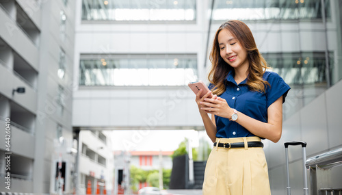 Woman wearing blue shirt walking and texting on her cellphone in the city. Young girl using smartphone app to stay connected and shop online.