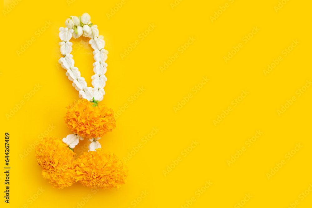 Obraz premium Jasmine garland with marigold flower on yellow background