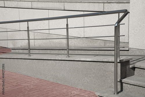 Ramp with metal handrail near building outdoors
