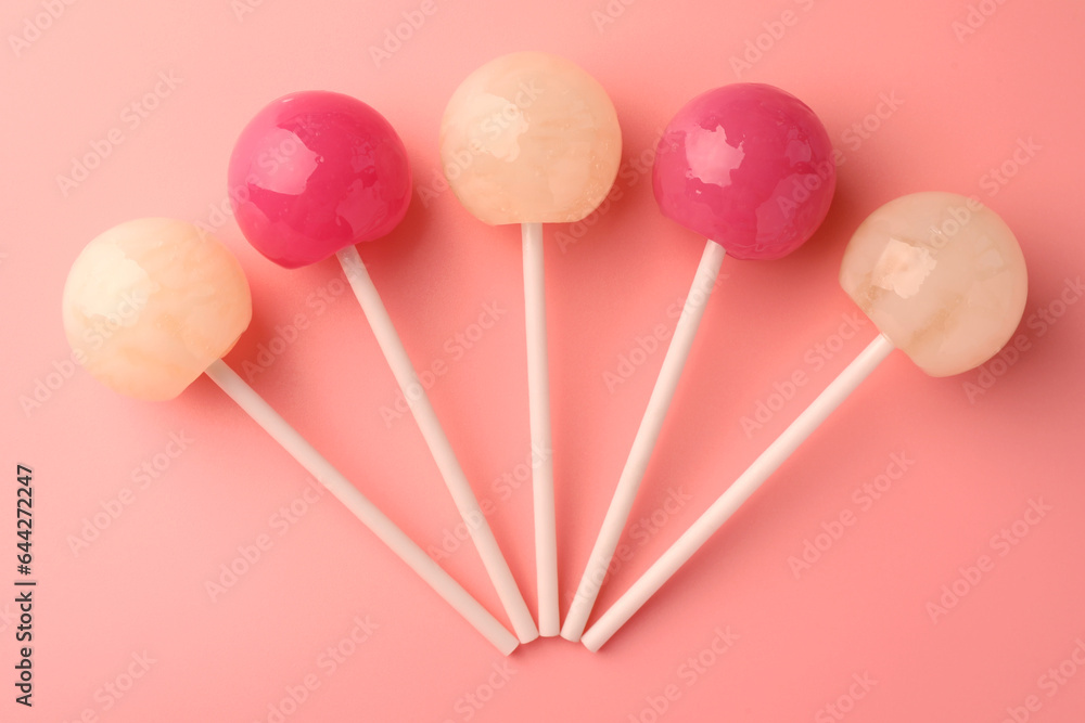 Tasty lollipops on pink background, flat lay Tasty lollipops on pink background, flat lay