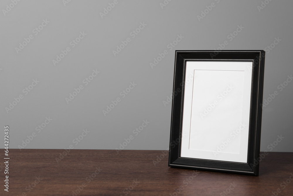 Empty square frame on wooden table, space for text Empty square frame on wooden table, space for text