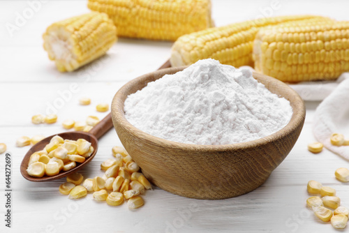 Bowl with corn starch and kernels on white table