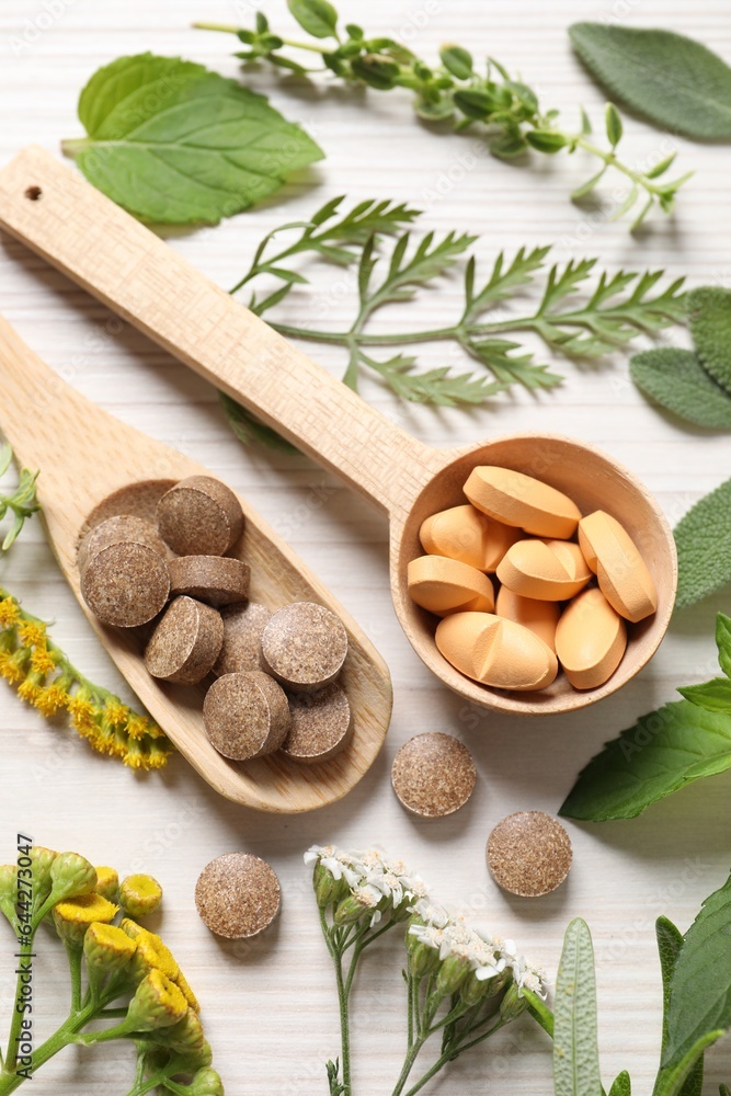 Different pills, herbs and flowers on white wooden table, above view. Dietary supplements Different pills, herbs and flowers on white wooden table, above view. Dietary supplements