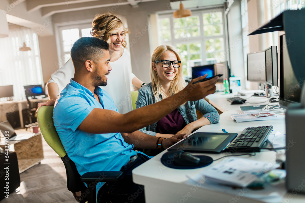 Young and diverse group of people working together in a startup company office Young and diverse group of people working together in a startup company office