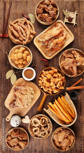 Fried meat food, unhealthy diet, indoor wooden table background, various fried foods placed on the table