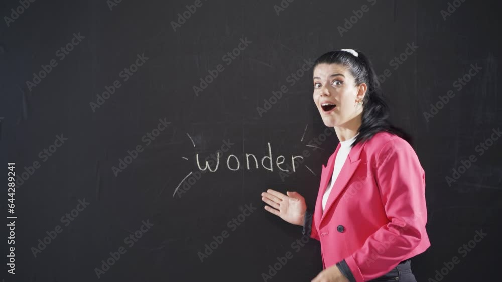 Woman writing surprise on blackboard is surprised at camera. Woman writing surprise on blackboard is surprised at camera.