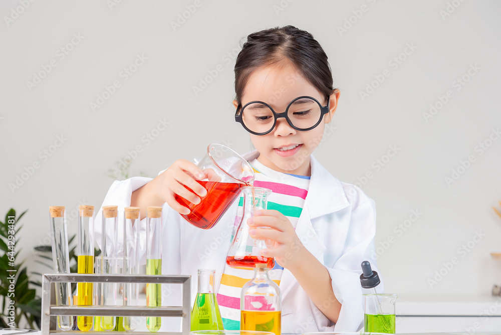 Asian little girl working with test tube science experiment in white classroom Asian little girl working with test tube science experiment in white classroom
