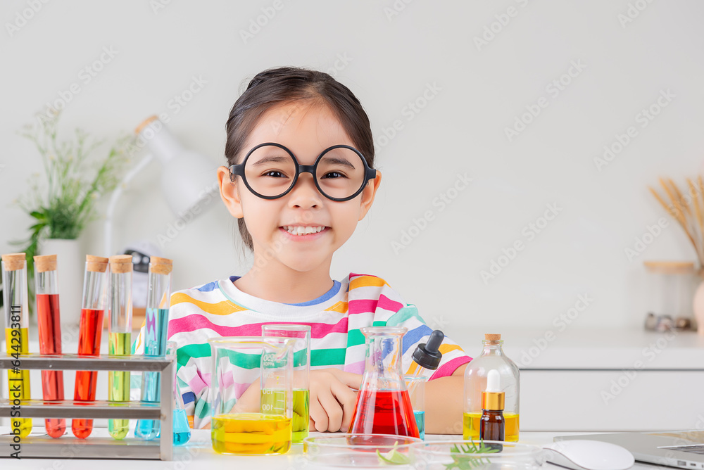 Asian little girl working with test tube science experiment in white classroom Asian little girl working with test tube science experiment in white classroom