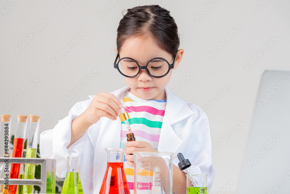 Asian little girl working with test tube science experiment in white classroom Asian little girl working with test tube science experiment in white classroom