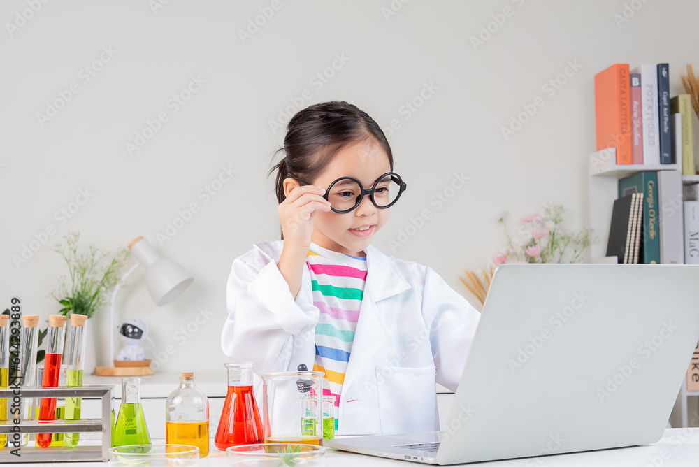 Asian little girl working with test tube science experiment in white classroom Asian little girl working with test tube science experiment in white classroom
