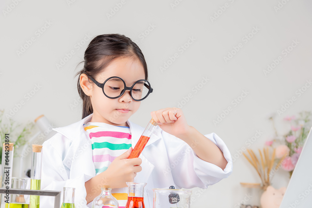 Asian little girl working with test tube science experiment in white classroom Asian little girl working with test tube science experiment in white classroom