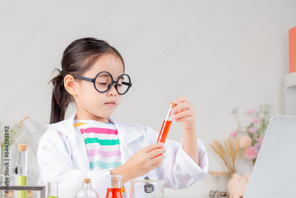 Asian little girl working with test tube science experiment in white classroom Asian little girl working with test tube science experiment in white classroom