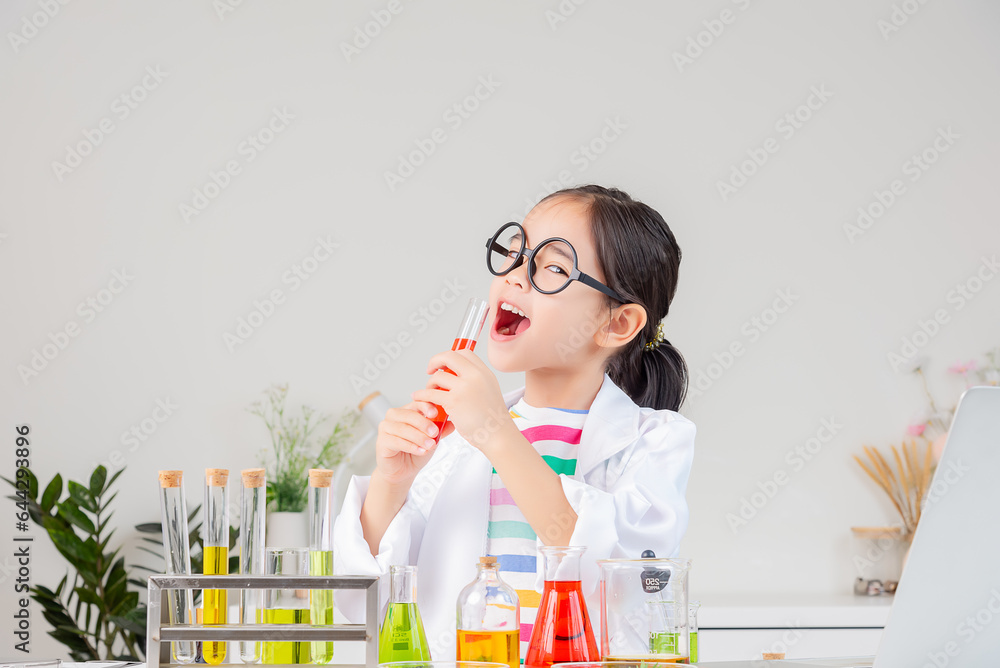 Asian little girl working with test tube science experiment in white classroom Asian little girl working with test tube science experiment in white classroom