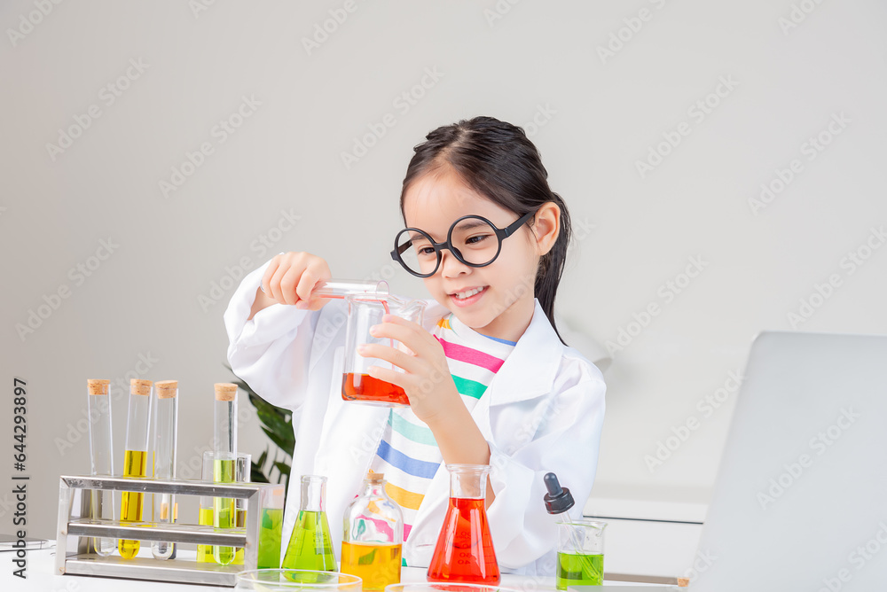 Asian little girl working with test tube science experiment in white classroom Asian little girl working with test tube science experiment in white classroom