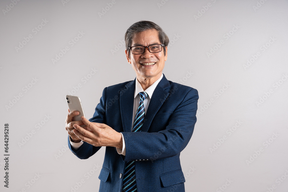 Portrait of an elderly Asian businessman, posing on a blue background Portrait of an elderly Asian businessman, posing on a blue background