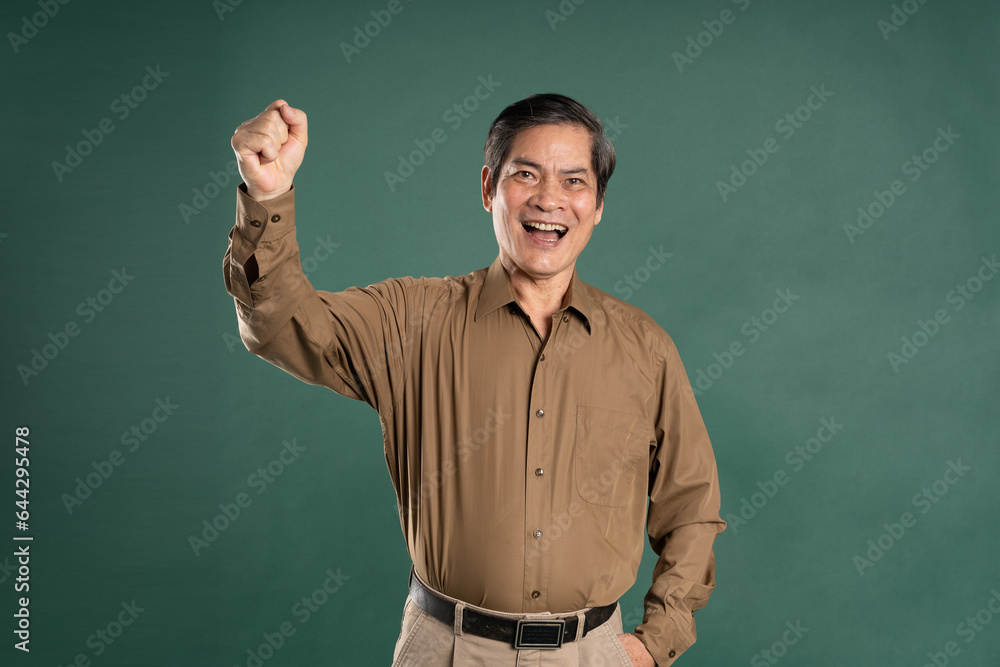 portrait of middle aged asian man posing on blue background