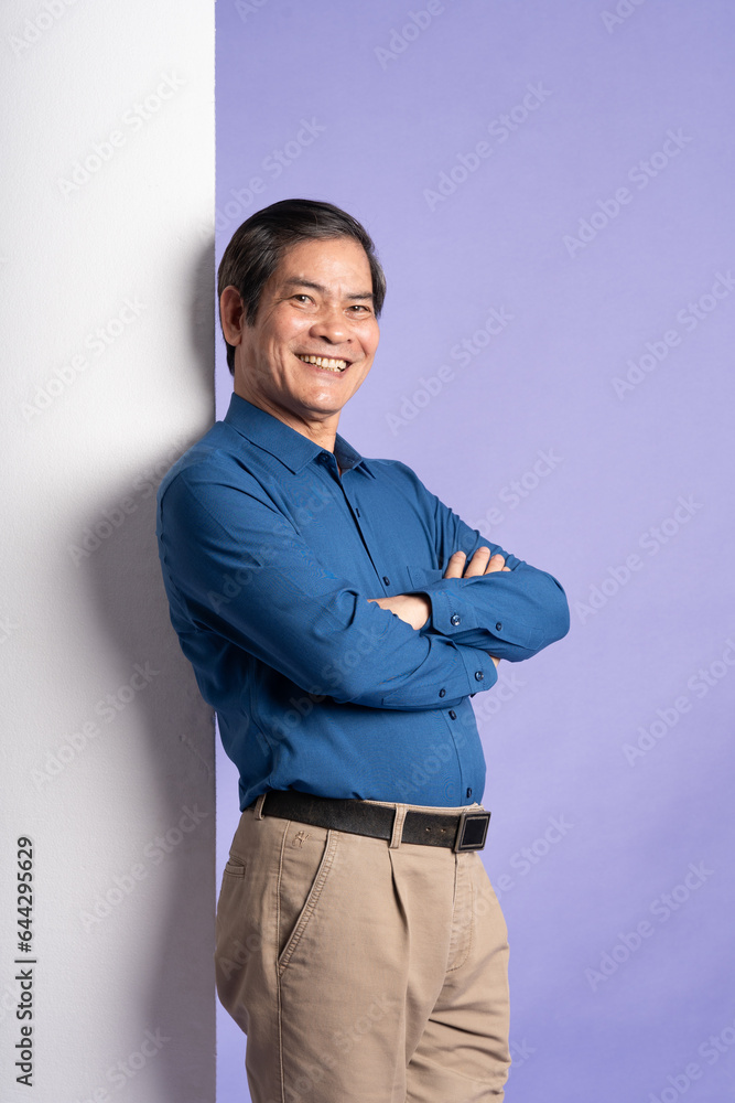 portrait of middle aged asian business man posing on purple background portrait of middle aged asian business man posing on purple background