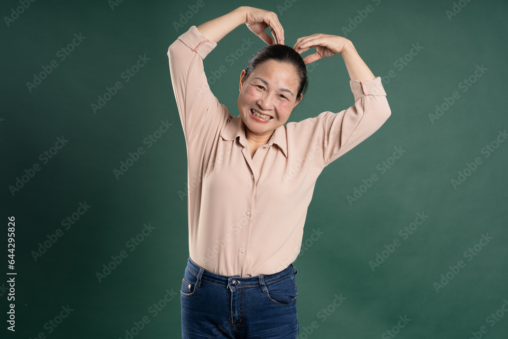 Gangang middle-aged Asian female portrait posing on blue background