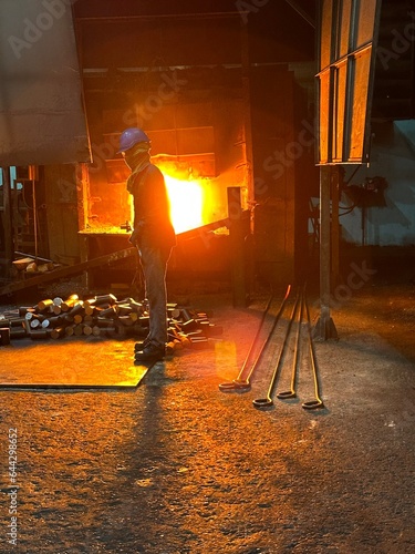 A blacksmith's furnace which uses a flame tongue with a metal rod.