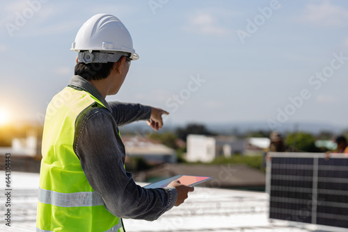 Young engineer asia is checking with a tablet the operation of the sun and the cleanliness on the field of solar panels at sunset. Concepts: renewable energy, technology, electricity, service, green,