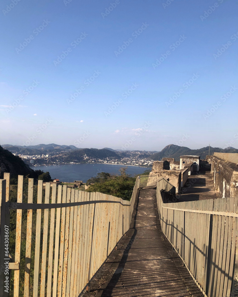 Obraz premium Descent ramp with railings on both sides in a fort overlooking the sea and mountains. clear sky day