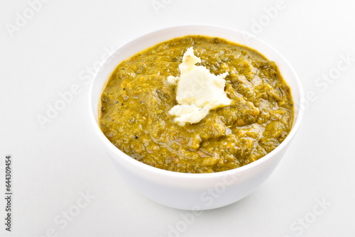 Sarson saag in bowl with white butter on white background