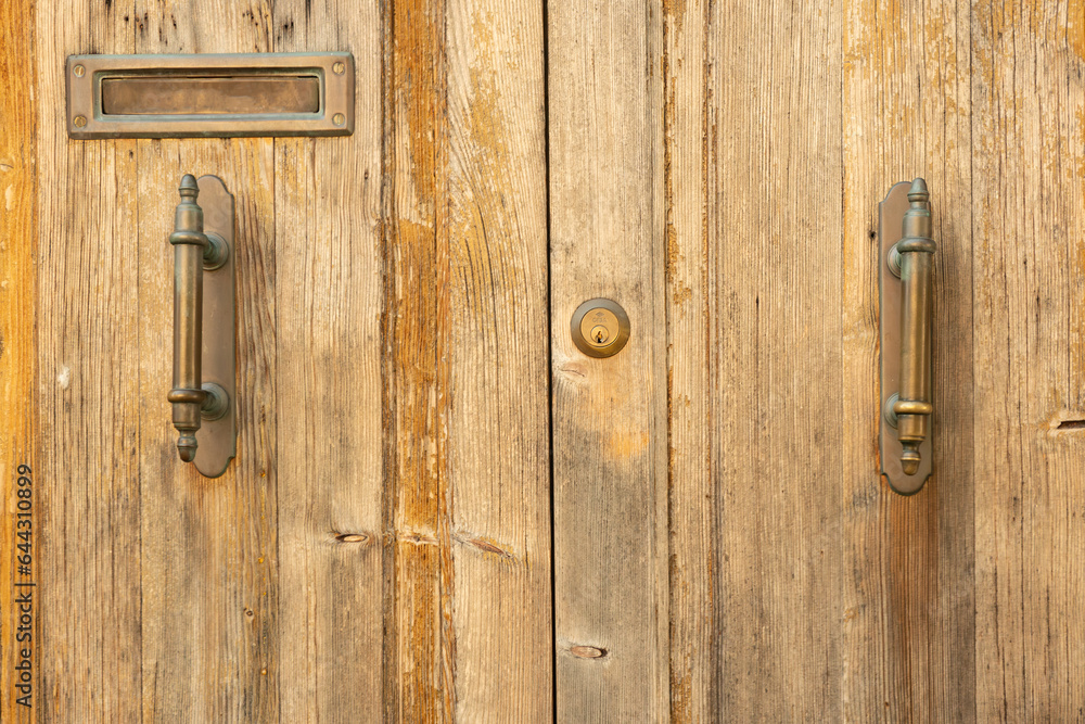 Fototapeta premium Part of an old wooden door with metal handles