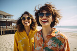 Picture of couple of women standing on top of sandy beach. This image can be used to depict friendship, vacation, travel, or relaxation.