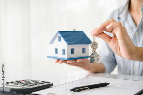 Wallpaper Mural Real estate agent with house model and keys Torontodigital.ca