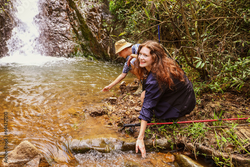 Fototapeta Naklejka Na Ścianę i Meble -  Nature hiking trip : Caucasian couple travel to Thailand's national parks during the summer relax in waterfalls, natural streams lush forests have fun enjoy hiking in the tropical mountains.