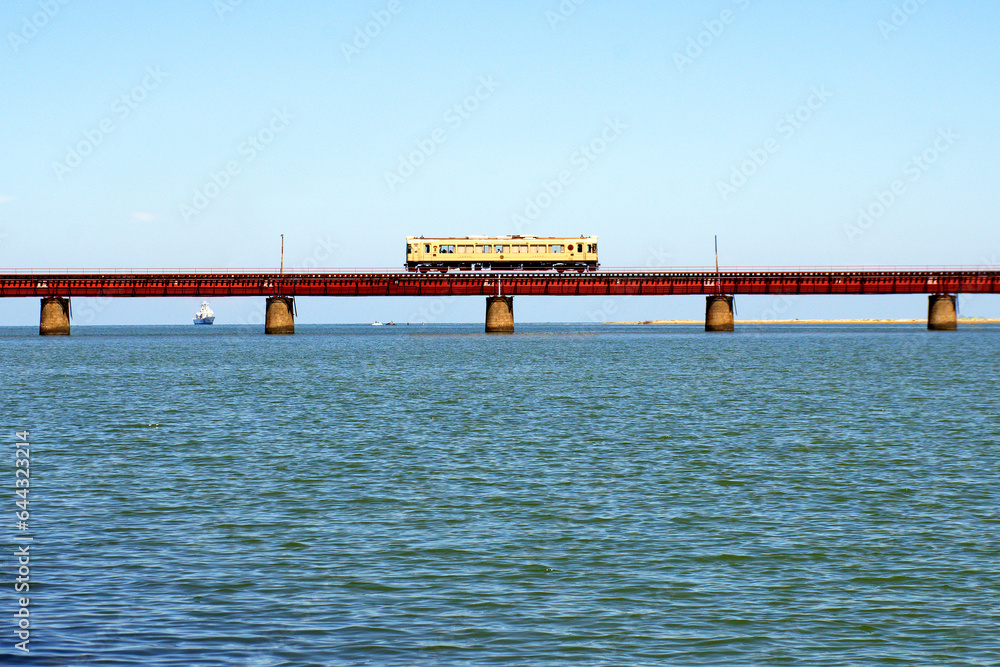 Train running on Yura railway bridge, 6 meters above the river surface in Kyoto Prefecture, Japan