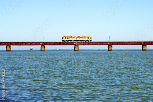Train running on Yura railway bridge, 6 meters above the river surface in Kyoto Prefecture, Japan photo
