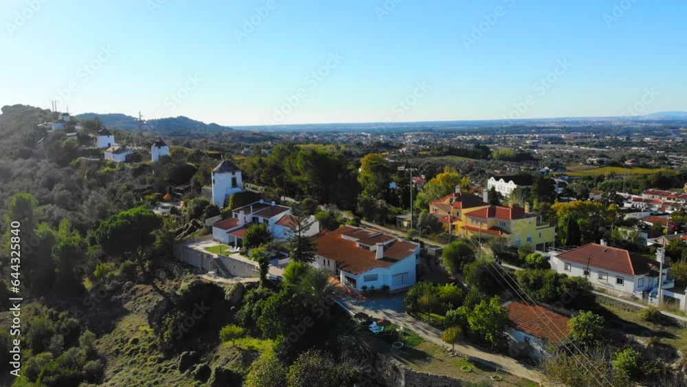 Drone shot of some houses and windmills on the ridge in Palmela, Portugal. Drone shot of some houses and windmills on the ridge in Palmela, Portugal.