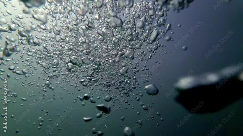 Cinematic underwater shot of air bubbles in slow motion in dark waters Cinematic underwater shot of air bubbles in slow motion in dark waters